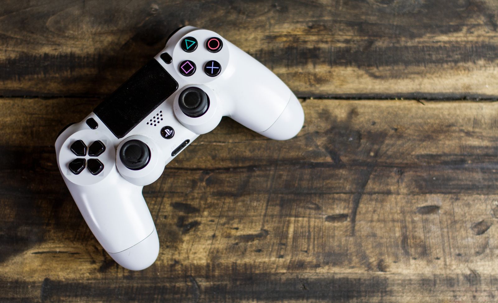 DualShock 4 kontroler na drvenom stolu — PS4